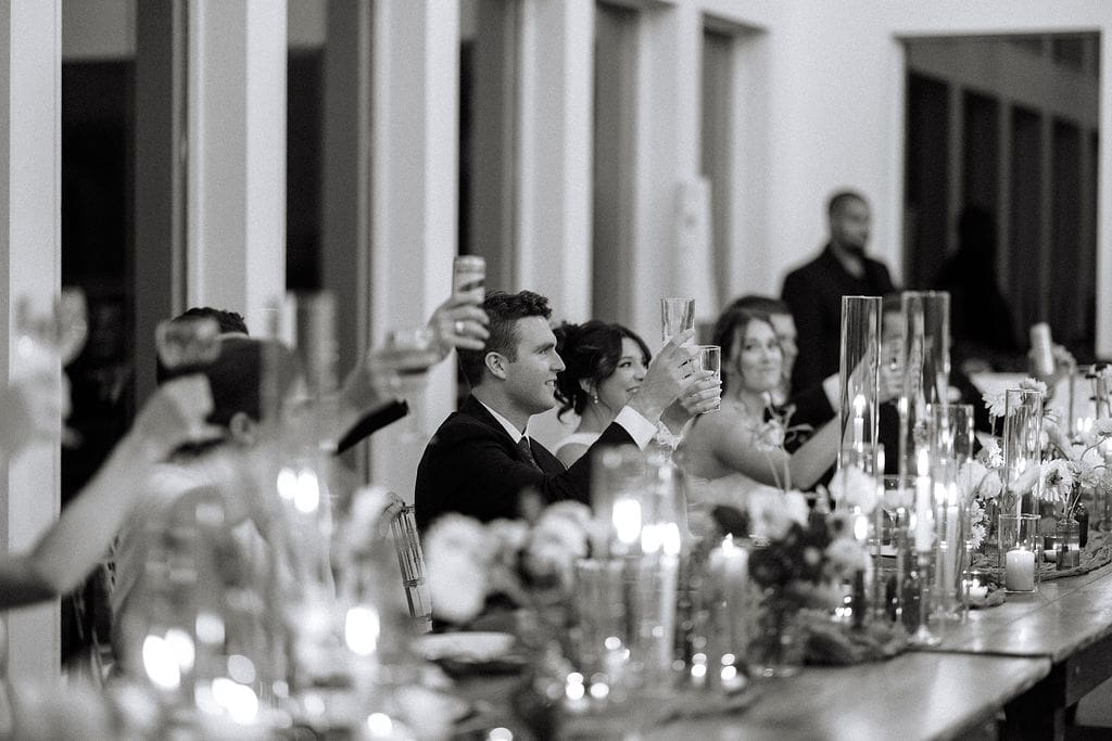 candid moment of groom and bride toasting at Sassafras Springs Vineyard and Winery