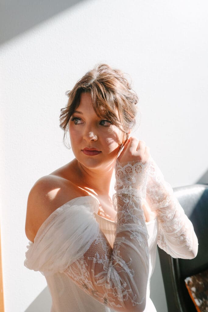 bride puts on jewelry on before ceremony