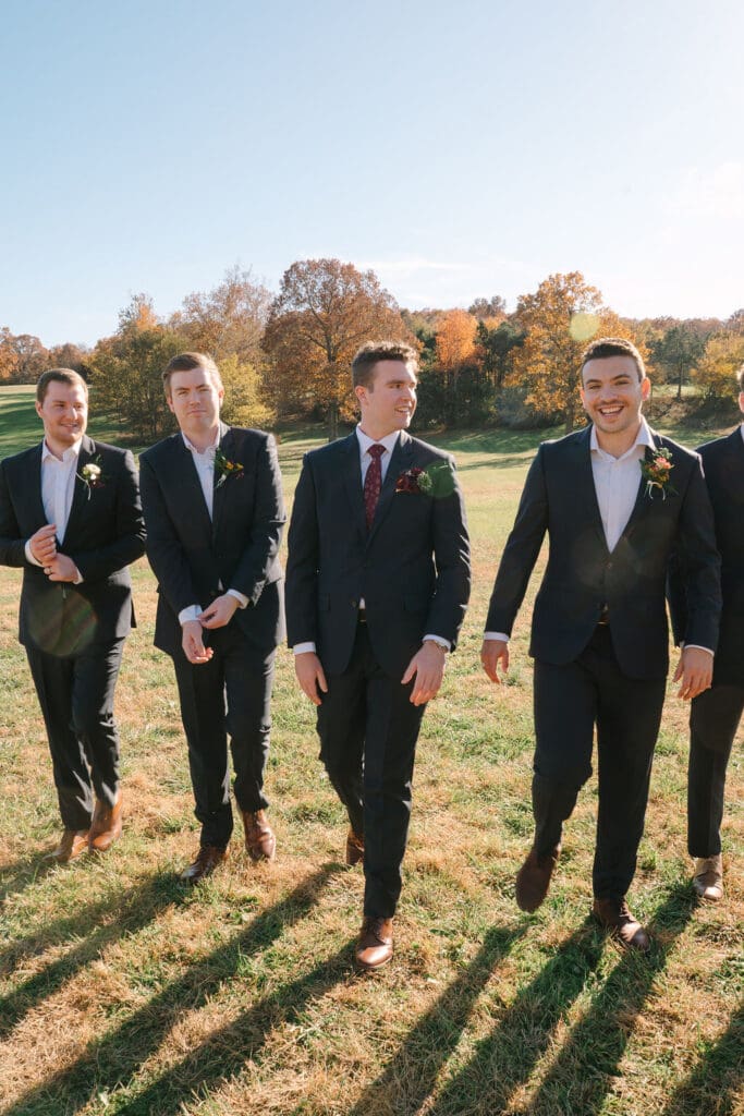 Groom walking alongside his groomsmen at Sassafras Springs Vineyard and Winery