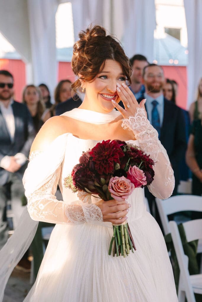 bride tears up while walking down aisle at her ceremony at Sassafras Springs Vineyard and Winery