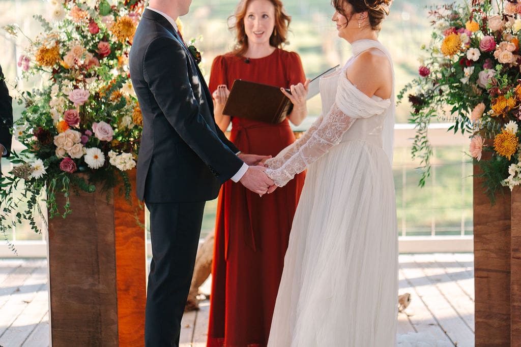 bride and groom hold hands during ceremony at Sassafras Springs Vineyard and Winery
